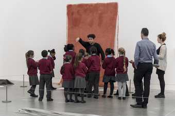 A group of children looking at an artwork