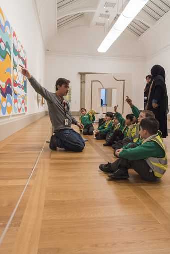 An artist speaking to children in the gallery