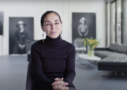 artist in a black polo neck top sitting in her studio talking to the camera