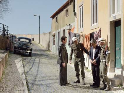 people stand in army uniform outside a house