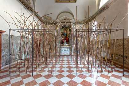 installation view of lots of branches standing up in a gallery space