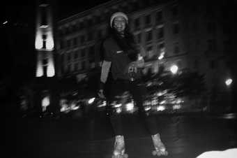  A person happily rollerskates through a city at night 