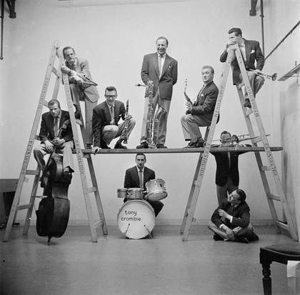 black and white photograph of a band on and around ladders, about 1949 to 1956