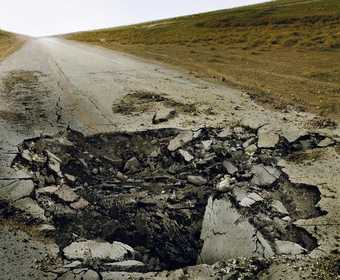 Sophie Ristelhueber Eleven Blowups 1 2006 photograph of a road where a middle section has been destroyed