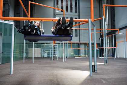 two woman sit on the swings