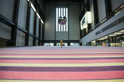 a woman stands and looks up at the ceiling