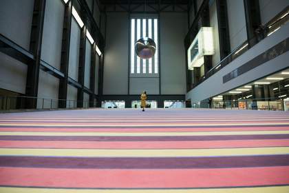 a woman stands and looks up at the ceiling