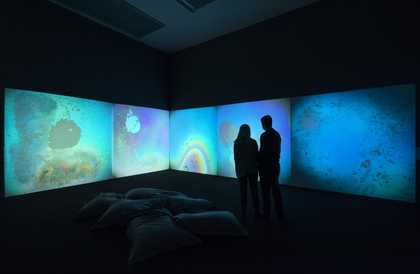 two people stand in front of a projection