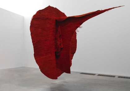 Dark red floating sculpture made of a frayed fabric in an oval shape with a pointed petrusion