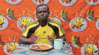 Still from Table Manners: "Alex Eats Roasted Cocoyam with Palm Oil" 2015 Video by Zina Saro-Wiwa, screening at Tate Britain, 18 January 2016