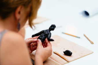 Woman making a figure out of modelling clay at a Talking Art event at Tate St Ives