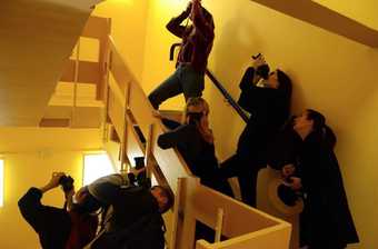 Photograph of Thomas Tallis School students photographing in a stairwell.