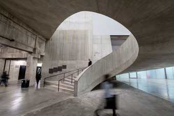 a person walks up some spiral stairs in Tate Modern's Tanks