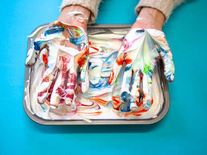 Hands in foam with marbled ink