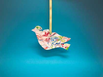 bird made from marbled paper hanging on a ribbon 