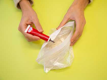 Adding food dye to rice in a plastic bag