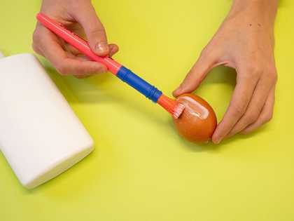 Egg being covered with PVA using a brush 