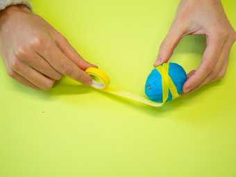 Egg being wrapped in yellow tape 