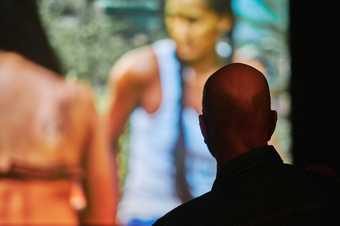 close up of visitor watching a film in a dark room