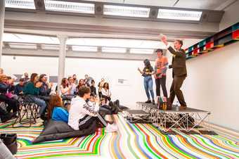 A large audience sitting on the floor watching a performance