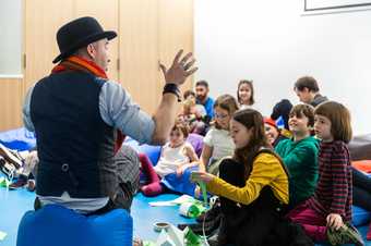 man in bowler hat telling a story to kids 
