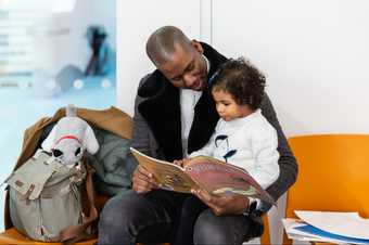 An adult reads to a child from a story book