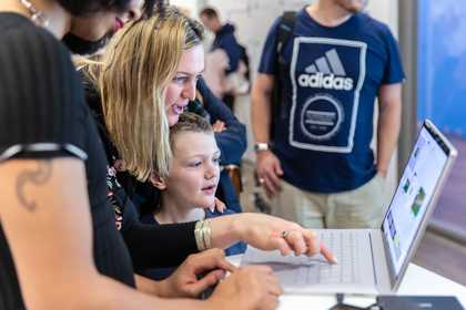 Boy looking at computer with parent