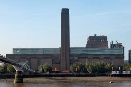 A tall tower in front of a large brick building