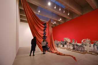 large red sail hanging from ceiling in gallery space