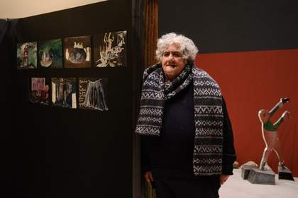 artist with her artwork in gallery