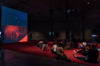 A group of teachers sitting on the floor watching a film