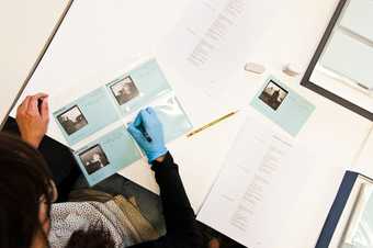 Tate Britain preservation volunteer Nella re-numbering Keith Piper photographs