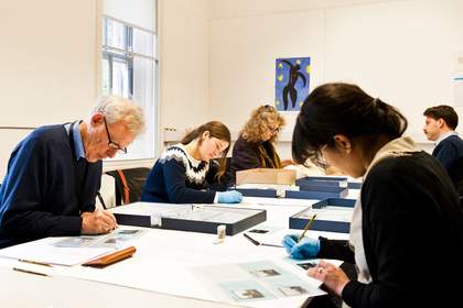 Tate Britain preservation volunteers Ben, Marina, Tara, Aurelio and Nella sat around a table working on mixed collections
