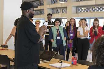 Participants on the Tate Intensive course gather round workshop leader and artist Harold Offeh