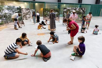 Kids sitting in a circle on the floor drawing