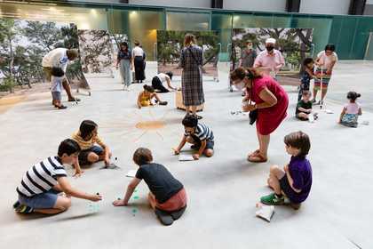 Kids sitting in a circle on the floor drawing