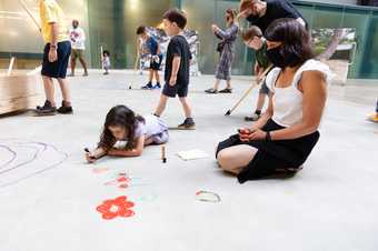 a parent and child draw together on the floor 