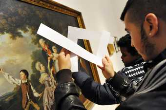 Photo of young person exploring an artwork with a viewfinder