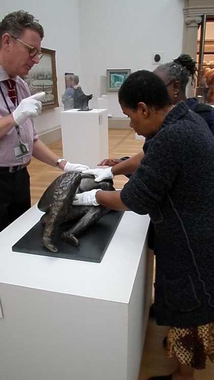 A woman handles a sculpture in the 1940s room at Tate Britain, during a touch tour