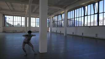 A photograph of a person dancing in an interior building