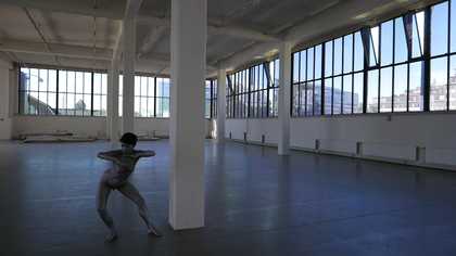 A photograph of a person dancing in an interior building