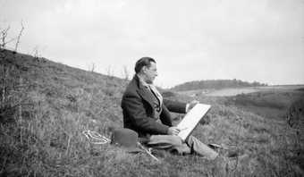 Archive photograph of Paul Nash on a hill sketching
