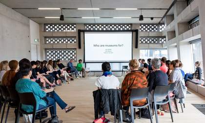 A group of participants sitting in a circle looking at a presentation