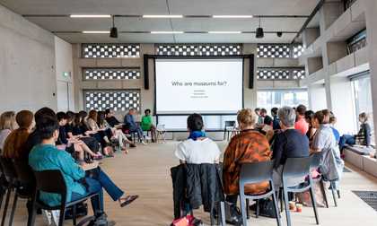 A group of participants sitting in a circle looking at a presentation