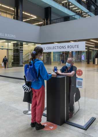 A visitor having their ticket scanned by a member of staff.