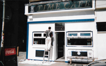  A person paints the outside of Time Café 