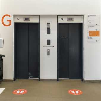 a set of lifts with signage on the floor showing where you can stand.