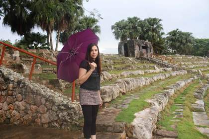 film still of a woman holding an umbrella in a public park in Havana