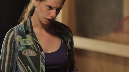 Cara Tolmie Pley 2013 video still showing a woman with a stern gaze looking down