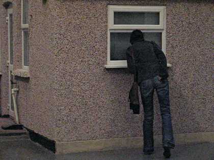 Video still of spectators looking at Michael Landys installation Semi detached at Tate Britain two